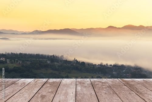 Empty old wooden balcony terrace floor on viewpoint high tropical layer mountain with white fog in early morning © Soonthorn