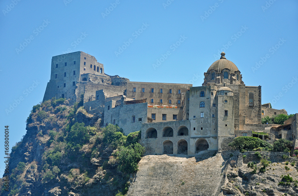 Aragonese castle on a cliff on the background of blue sky