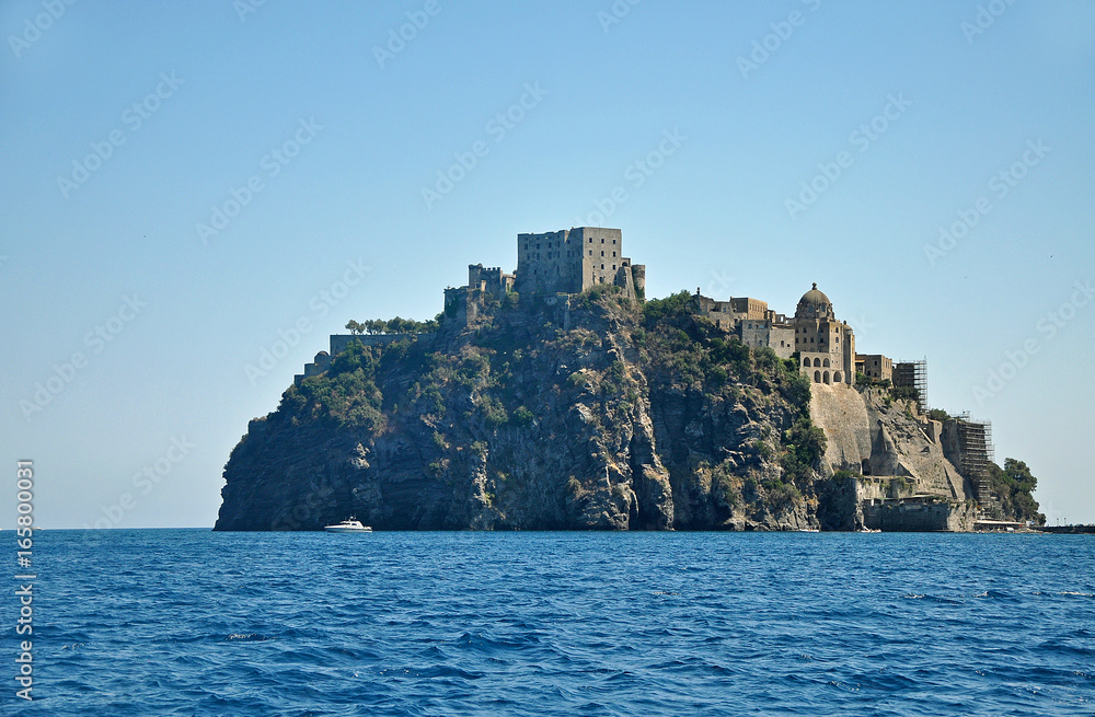 Aragonese castle on a cliff on the background of blue sky and blue sea