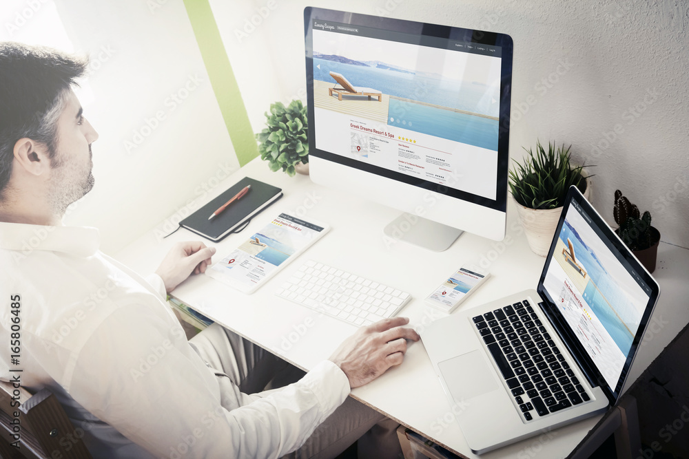 man working with devices resort and spa responsive website man working with devices resort and spa responsive website