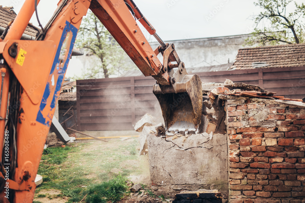 Fototapeta premium bulldozer crushing an old building at construction site