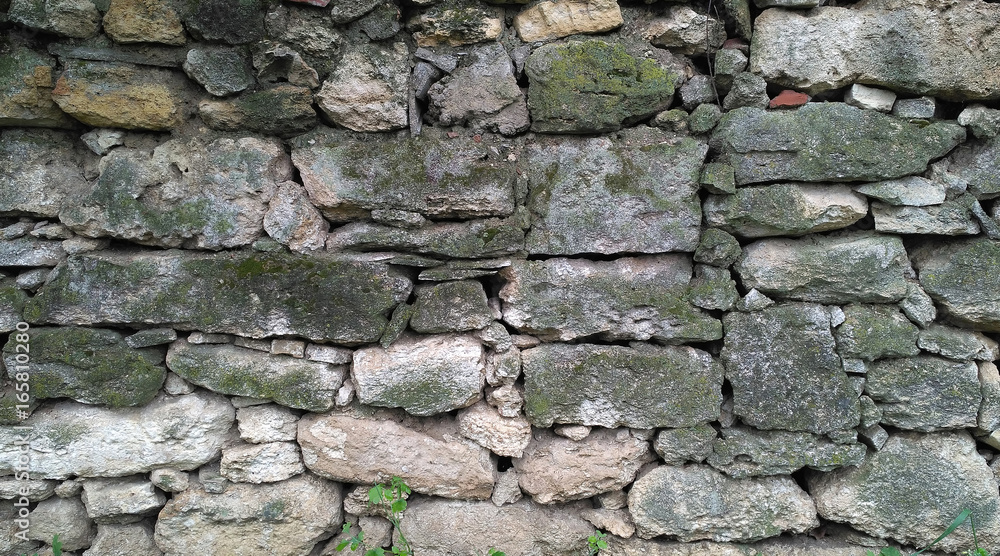 Old masonry of irregularly shaped green mossy stones. Aged stonework_2 Old masonry of irregularly shaped green mossy stones. Aged stonework_2