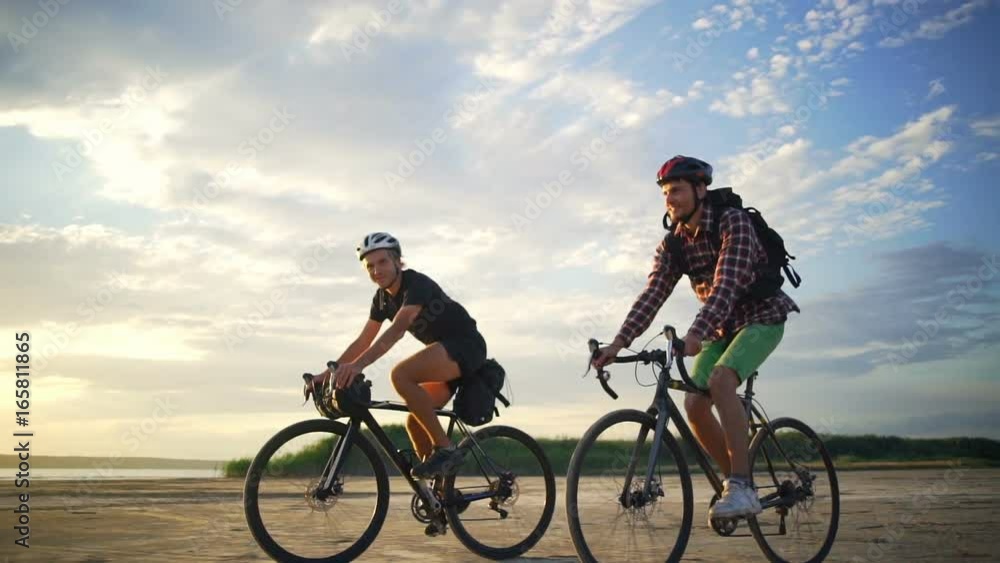 Happy cyclists rides together equipment sand seaside dawn slow motion rapid Happy cyclists rides together equipment sand seaside dawn slow motion rapid