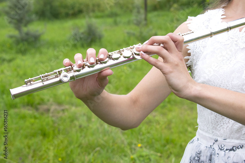 Girl playing the flute in the garden.