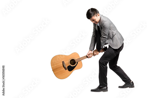 Portrait of a young business man smashing his guitar. Isolated on white background with copy space and clipping path