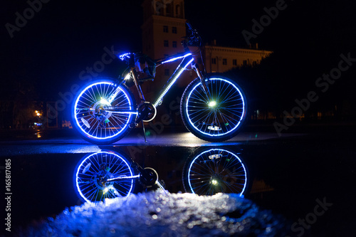 Glowing bicycle is reflected in the water.