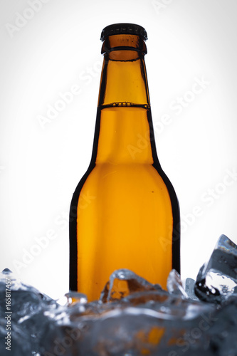 Bottle of malt in ice cubes. Close up. White background