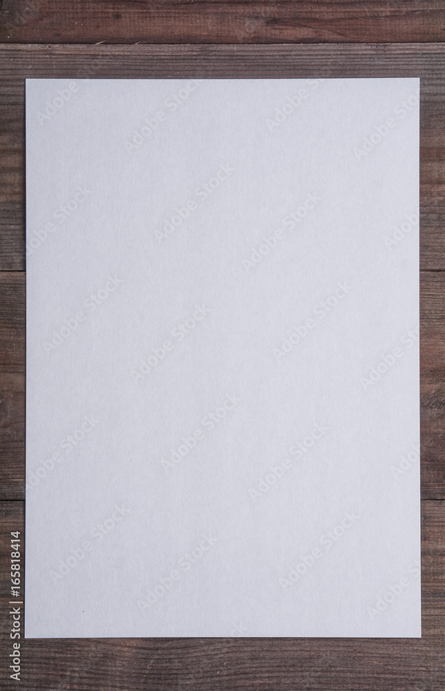 Fototapeta premium empty sheet of paper on dark wooden desk