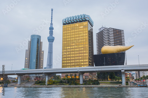 Tokyo skytree and Asahi tower with Sumida river in evening.