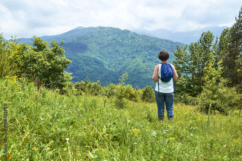Hiker woman with backpack enjoying beautiful mountain view