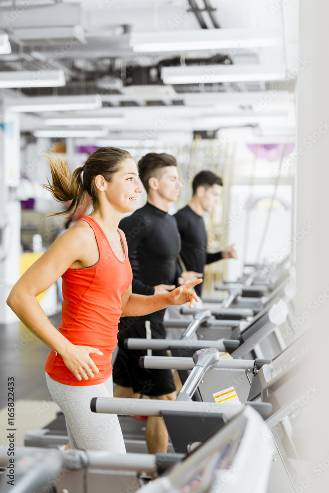 Group of young people using treadmills in a gym