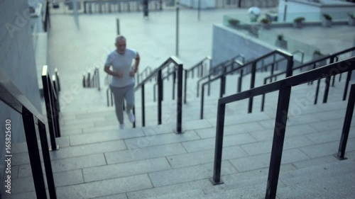Wallpaper Mural Senior sporty man resting after running on the staircases Torontodigital.ca