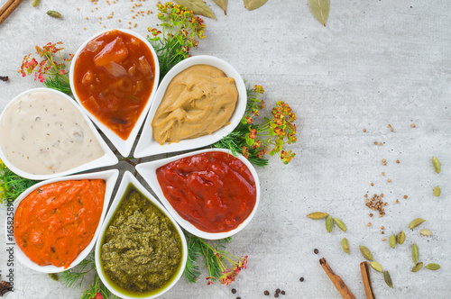 A tasty assortment of sauces in a form of flower with spices and herbs.