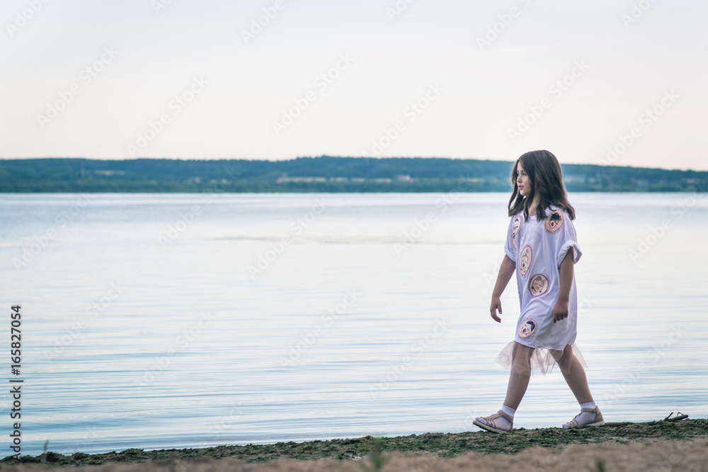Portrait of little fashionable girl walking on berth near sea Portrait of little fashionable girl walking on berth near sea