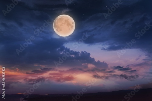 Obraz na płótnie Glowing sunset and full moon . Beautiful cloudy sky. Cloudy abstract background. Sunset colors. w salonie