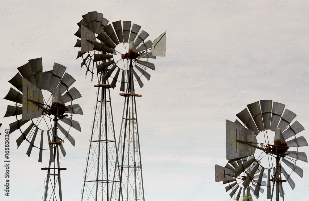 collection of four windmills with a gray sky background collection of four windmills with a gray sky background