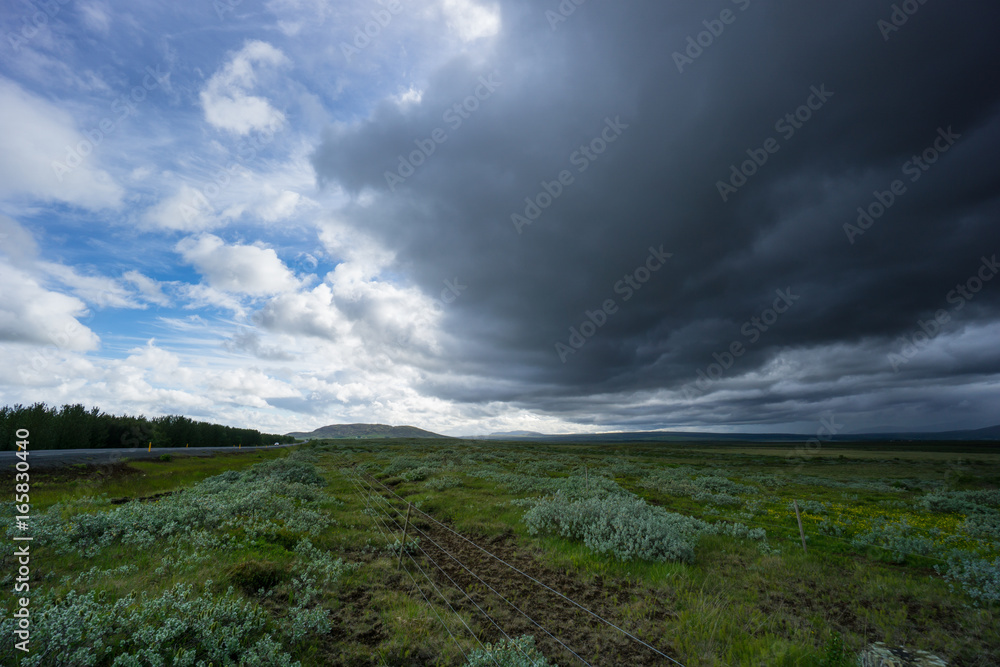 Iceland - Dark clouds and thunderstorm over green fields