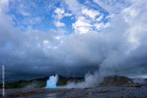 Iceland - Turquoise hot boiling water, begin of eruption of geyser strokkur