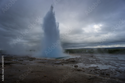 Iceland - Turquoise hot boiling water, end of eruption of geyser strokkur with trees