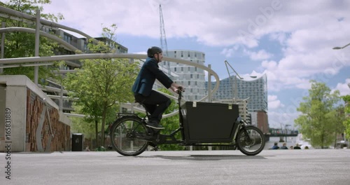 Architect is riding with his cargo bike through the city. Hamburg