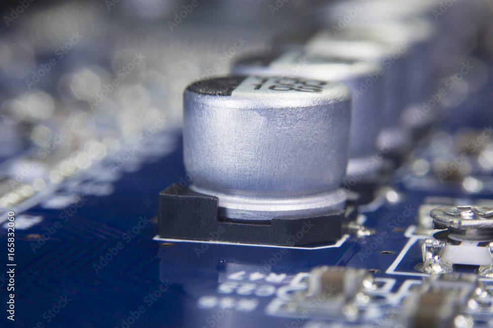 Close up macro of aluminum electrolytic capacitors installed on the motherboard and electronic component with selective focus. Electronics part concept. Close up macro of aluminum electrolytic capacitors installed on the motherboard and electronic component with selective focus. Electronics part concept.