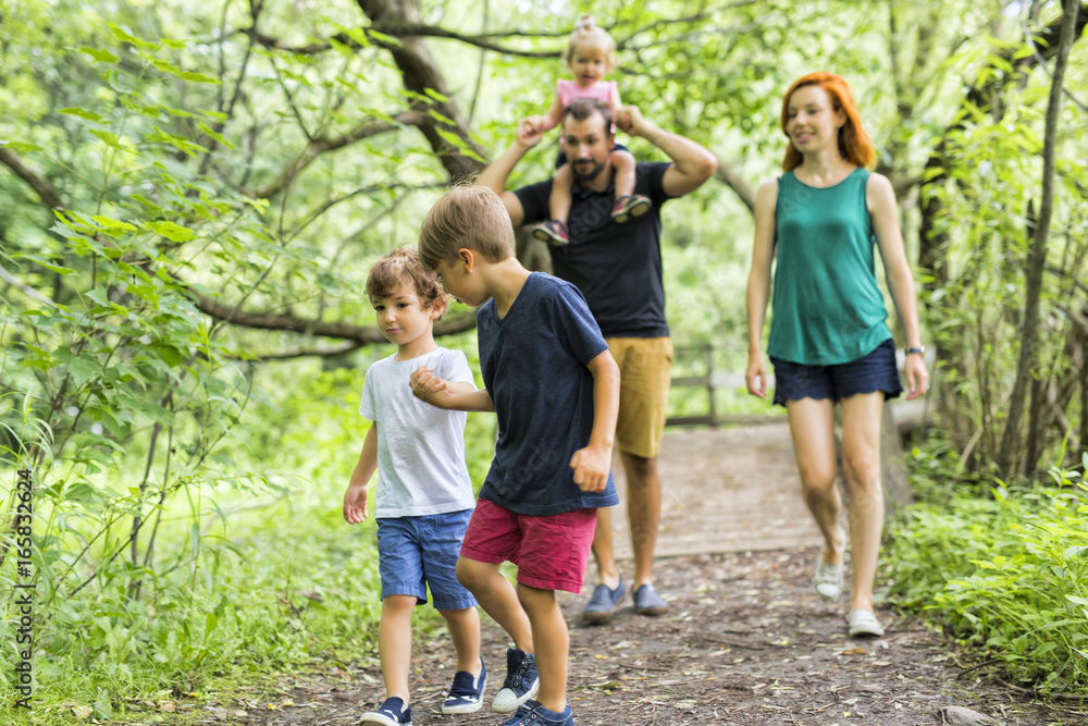 Happy young family walking outside in green nature Happy young family walking outside in green nature