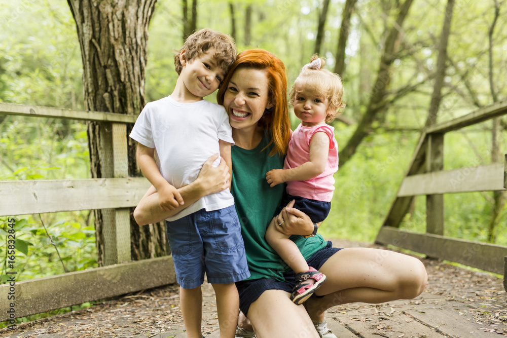 Fototapeta premium Young beautiful mother her little toddler daughter and son