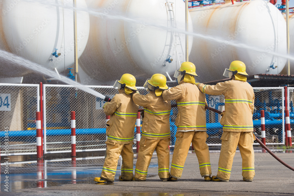 Fototapeta premium Firefighters spray water in LPG gas tanks, Fire extinguishers caused by explosive gas