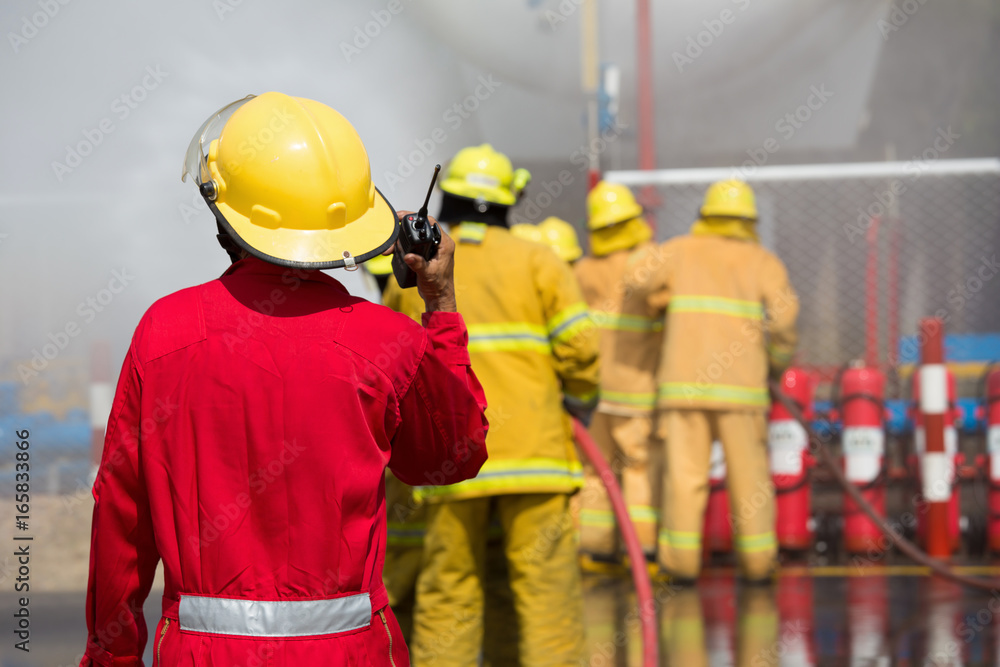 Fototapeta premium Firefighters spray water in fire extinguishers caused by explosive gas
