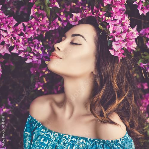 Beautiful young woman surrounded by flowers