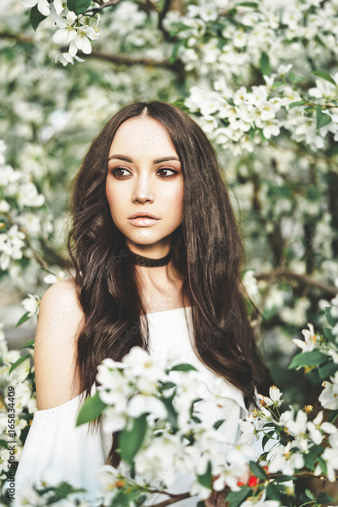 Beautiful young woman surrounded by flowers of apple-tree Beautiful young woman surrounded by flowers of apple-tree