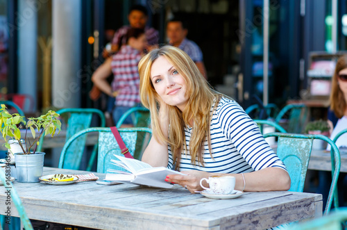 Photography Woman drinking coffee and reading book in cafe