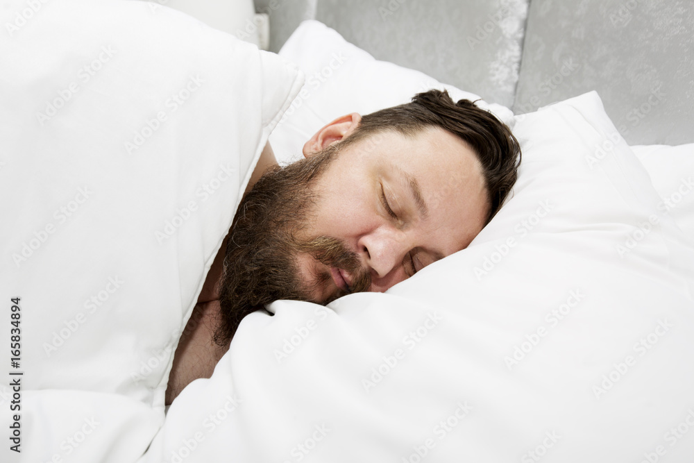 Attractive bearded young man sleeping in bed at home Attractive bearded young man sleeping in bed at home