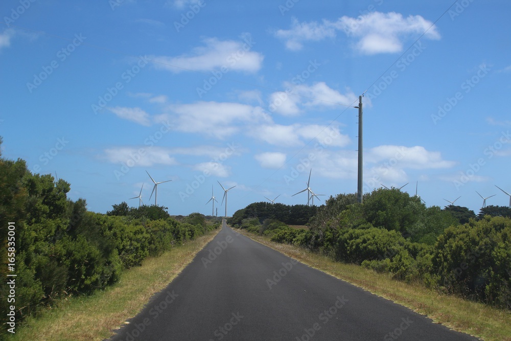Road through a wind farm against blue sky at Cape Bridgewater, Australia