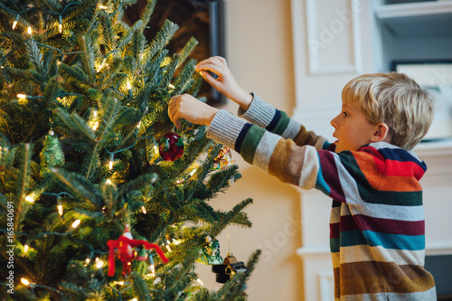 child decorating a Christmas tree photo