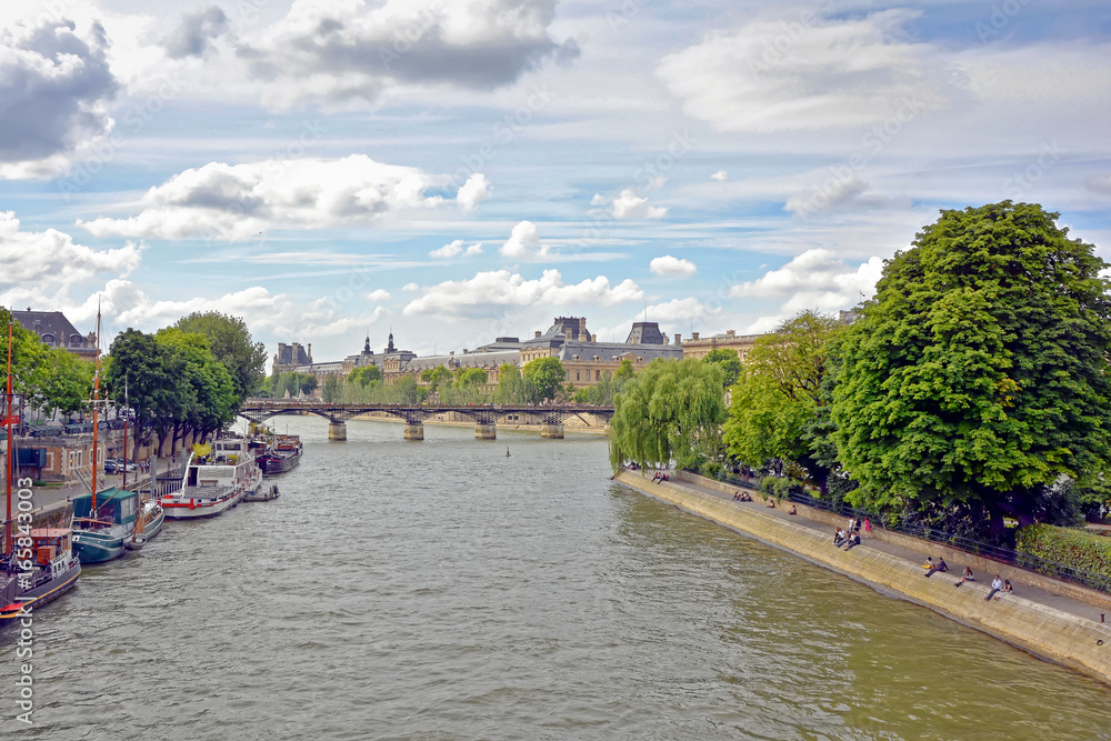 Seine River in Paris with its boats, architecture and people on the banks