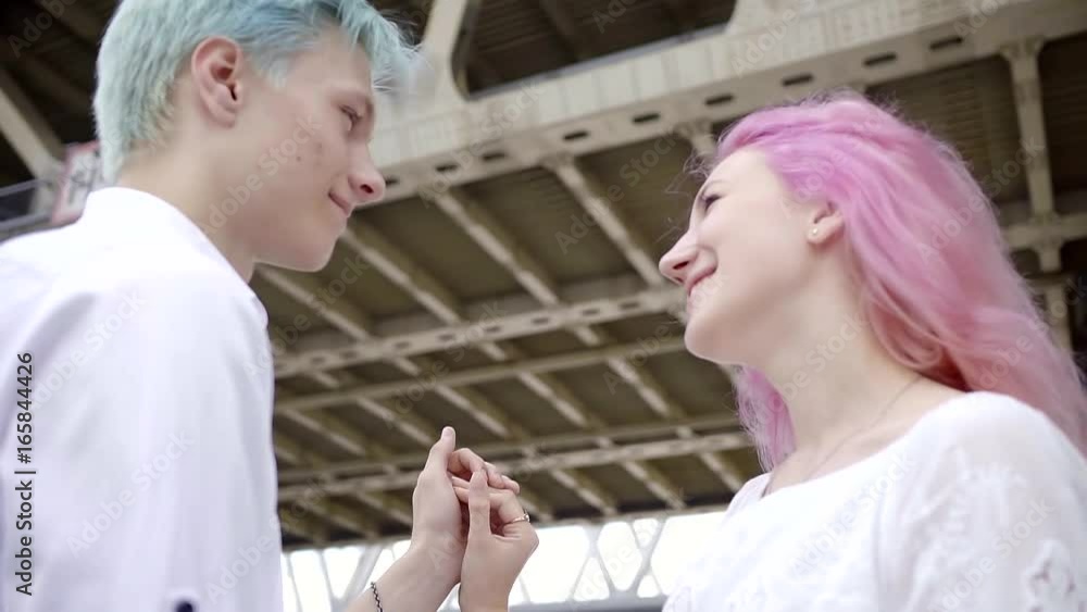 young couple in love under the bridge walking in a large modern city. look at other and smile. the gentle touch of his hands. lower plan, focus on palms young couple in love under the bridge walking in a large modern city. look at other and smile. the gentle touch of his hands. lower plan, focus on palms