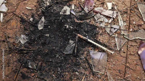 Wallpaper Mural syringe falling down spraying blood after a heroin cocaine injection on broken glass. Torontodigital.ca