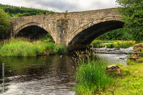 Old stone bridge over river Dee, Wales photo