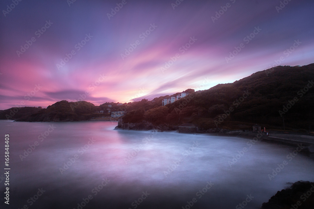 The sea at sunset on Caswell Bay, calmed down with a long exposure. One of the most popular, easily accessible and closest beaches to Swansea City, on the Gower peninsula, South Wales, UK