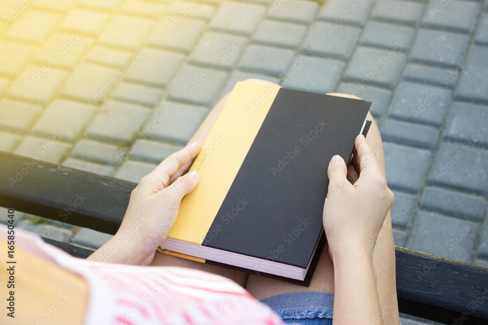Obraz premium Top view of a woman holding a book.