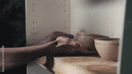 Hands of the master potter and vase of clay on the potter's wheel close-up. Master crock man. Twisted potter's wheel. photo