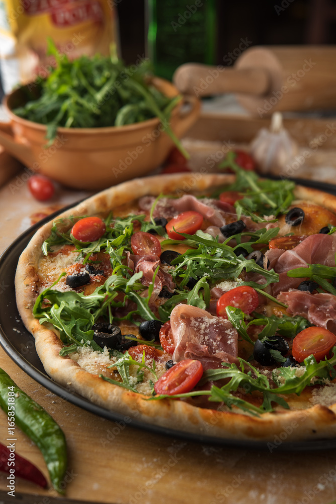 Traditional pizza with prosciutto and arugula Traditional pizza with prosciutto and arugula