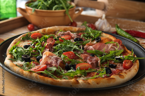 Traditional pizza with prosciutto and arugula