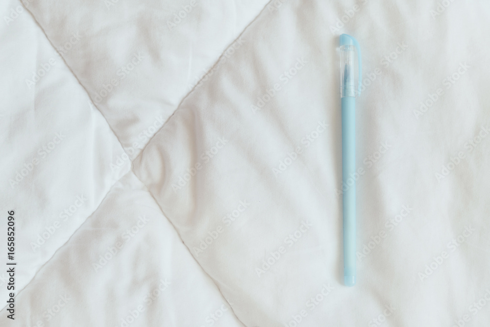 Blue pen on the white blanket Blue pen on the white blanket