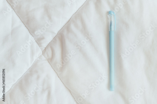 Blue pen on the white blanket photo