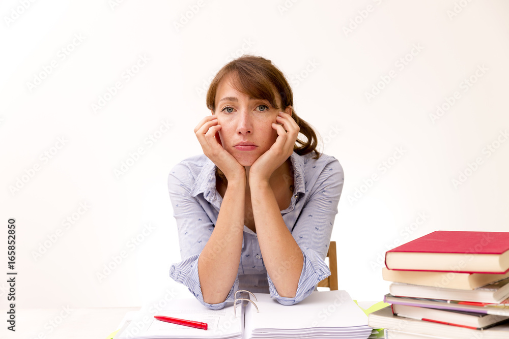 Young woman studying and reading in a library but is having a hard time understanding the material Young woman studying and reading in a library but is having a hard time understanding the material