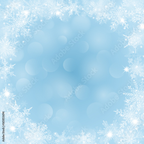 Christmas background with frame of snowflakes and bokeh effect in light blue colors