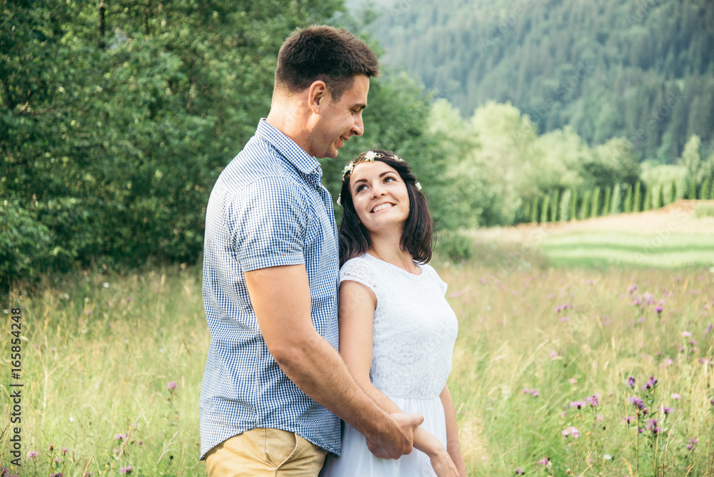 couple in love walking in feild with beautiful view on moutains couple in love walking in feild with beautiful view on moutains