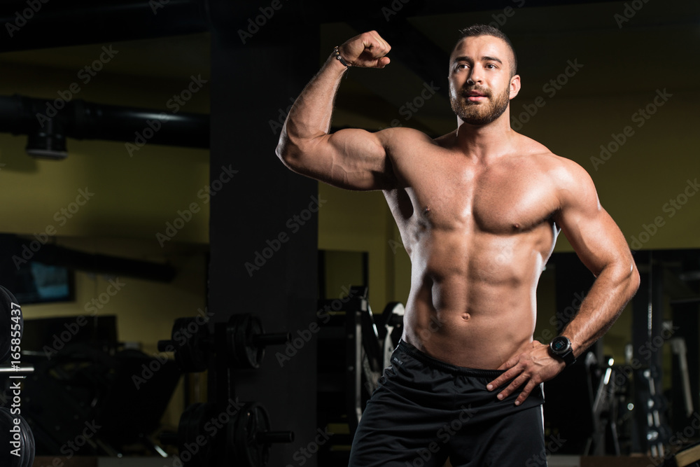 Handsome Muscular Man Flexing Muscles In Gym